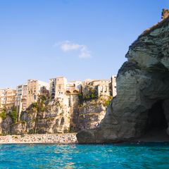 Houses on a cliff next to a cave in Tropea, Italy